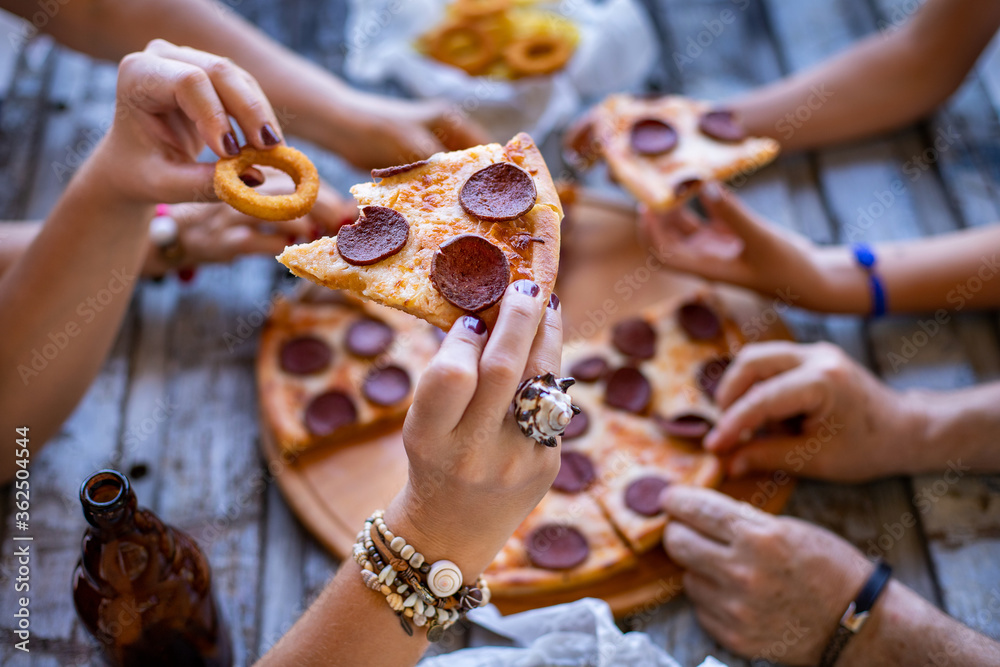 Obraz premium Many hand on the table with pizza slice