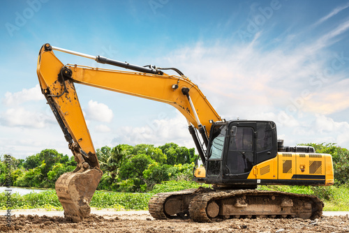 Excavator backhoe on the ground at construction site in blue sky background