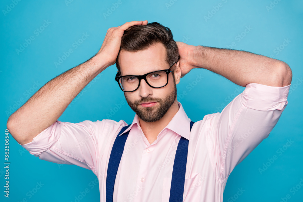 Closeup photo of handsome business man trend clothes hold arms head checking neat hairdo after salon styling wear specs pink shirt suspenders isolated blue color background Closeup photo of handsome business man trend clothes hold arms head checking neat hairdo after salon styling wear specs pink shirt suspenders isolated blue color background