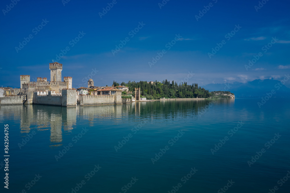 Sirmione, Lake Garda, Italy. The famous Sirmione Castle, good weather. Castle reflections in the water