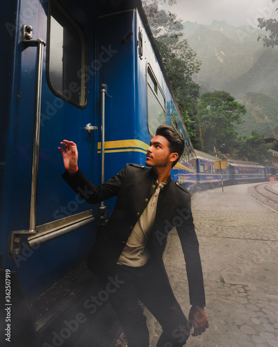 Man boarding a train with steam and motains on a jungle forest photo