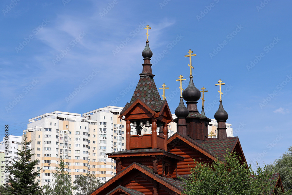 Wooden orthodox temple on residential buildings background. Church of Saints Constantine and Elena equal to the apostles in Moscow
