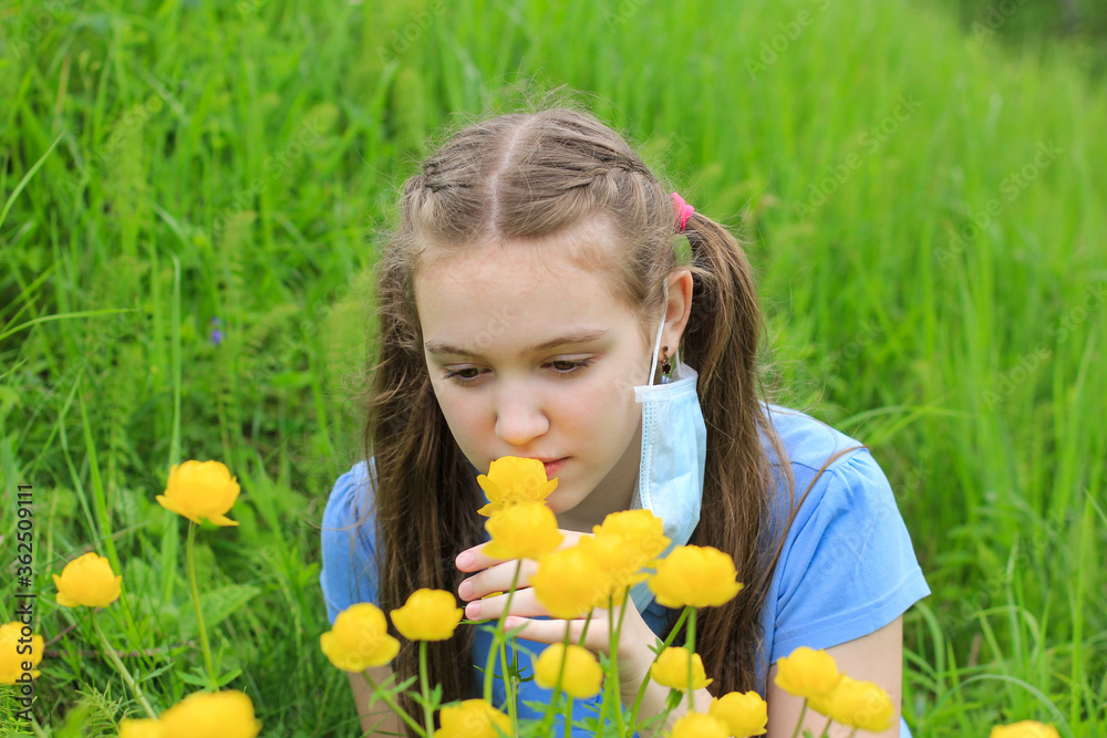 Happy cute teenager girl with long hair taking off face medical mask and sniffing flowers. Concept of the end of covid-19, coronavirus pandemic, allergy, seasonal allergic rhinitis, mask mode. Happy cute teenager girl with long hair taking off face medical mask and sniffing flowers. Concept of the end of covid-19, coronavirus pandemic, allergy, seasonal allergic rhinitis, mask mode.