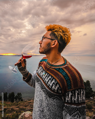 Man drinking a glass of wine at sunset photo