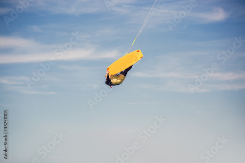 Professional kiter makes the difficult trick on a beautiful background. Kitesurfing Kiteboarding action photos man among waves quickly goes
