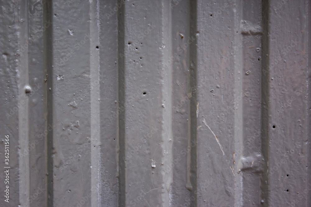 Corrugated sheet metal, badly painted with grey paint for background. Metal corrugated roofing sheet. Painting of metal surfaces for rust control. Abstract background for sites and layouts. Corrugated sheet metal, badly painted with grey paint for background. Metal corrugated roofing sheet. Painting of metal surfaces for rust control. Abstract background for sites and layouts.