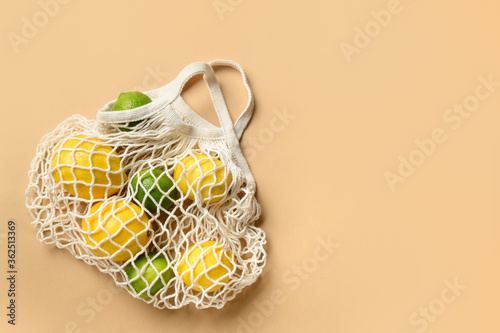 Shopping eco mesh bag with friuts, lemon, lime, banana on beige. Zero waste. View from above.