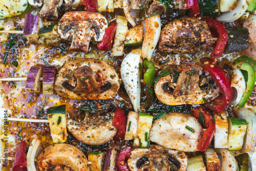 Vegan barbecue skewer. Vegetarian party food with very spiced eggplant, onion and pepper mushrooms. Focus on one point and the rest blurred Vegan barbecue skewer. Vegetarian party food with very spiced eggplant, onion and pepper mushrooms. Focus on one point and the rest blurred