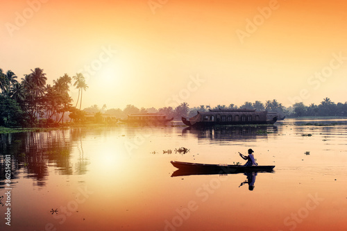 An unidentified woman sails her canoe in tranquil backwaters in
