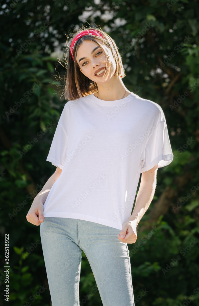 Woman or girl wearing white blank t-shirt with space for your logo, mock up or design in casual urban style Woman or girl wearing white blank t-shirt with space for your logo, mock up or design in casual urban style