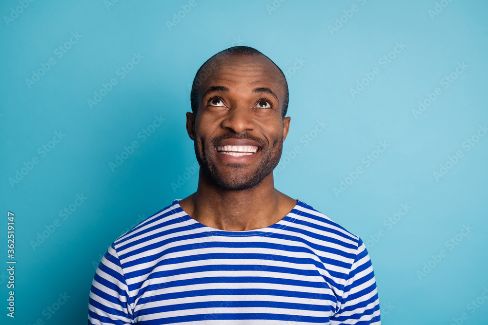 Portrait of satisfied candid guy wait for incredible surprise look up copy space enjoy wear nautical vest isolated over blue color background Portrait of satisfied candid guy wait for incredible surprise look up copy space enjoy wear nautical vest isolated over blue color background