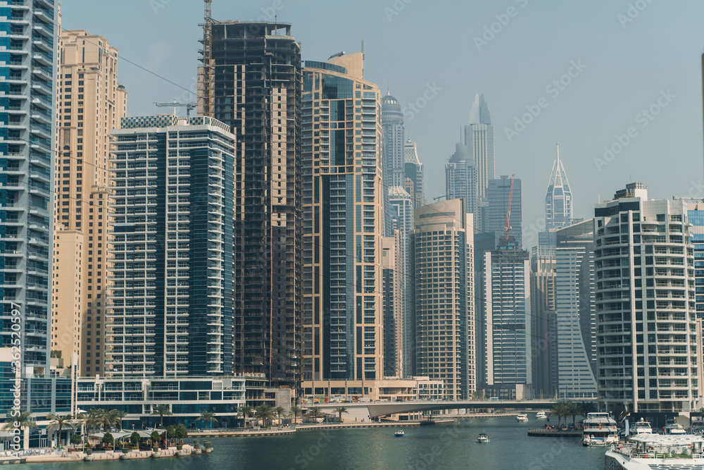 Dubai Marina skyscrapers with boats in water canal, Dubai, United Arab Emirates.