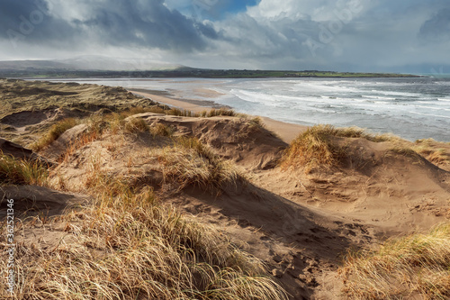 View on Strandhill beach  county Sligo  Ireland. Sandy dunes and cloudy sky. Warm sunny day  Nobody. Atlantic ocean on the right.