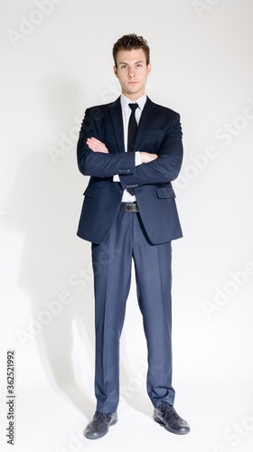 Full body shot of young handsome businessman in suit with arms crossed