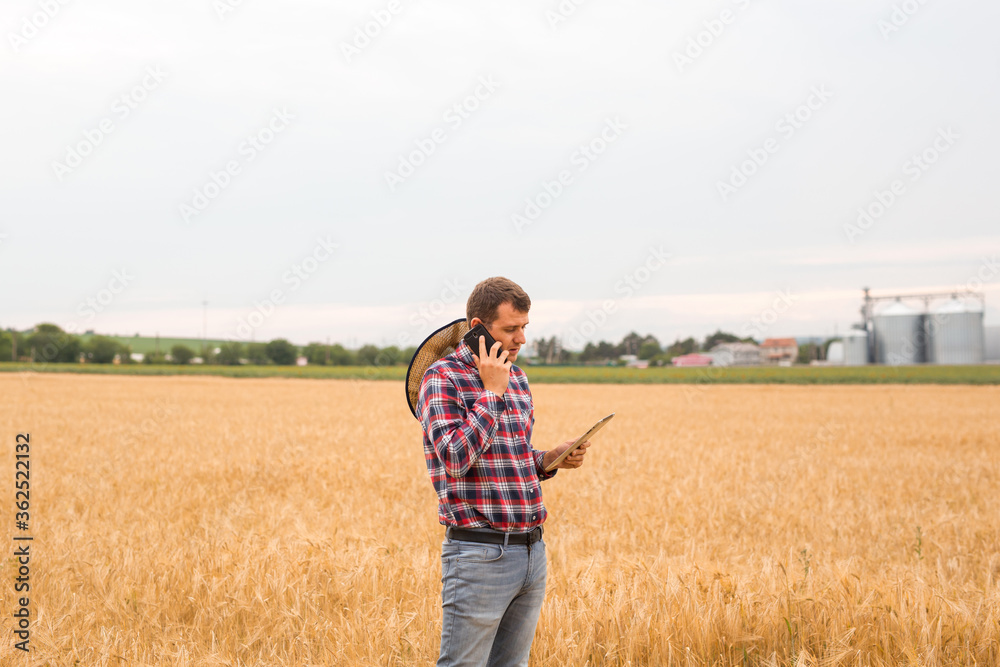 Caucasian farmer checking wheat field progress with tablet using internet. Agriculture and harvesting concept. Caucasian farmer checking wheat field progress with tablet using internet. Agriculture and harvesting concept.