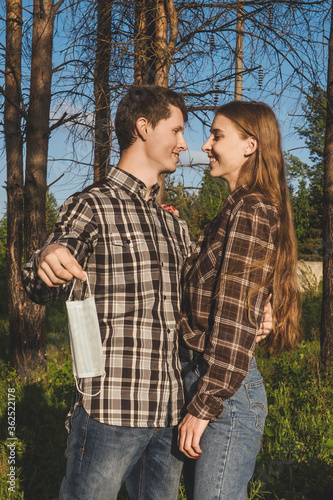 Happy couple takes off protective medical mask.