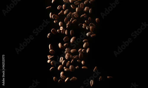 flying roasted coffee grains on a black background