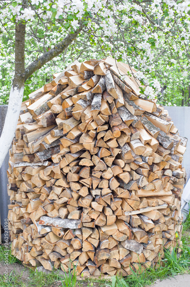 Stack of chopped firewood in the country, background