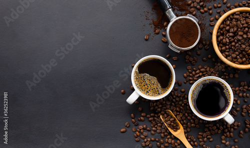 cup of coffee and bean on black wooden table background. top view