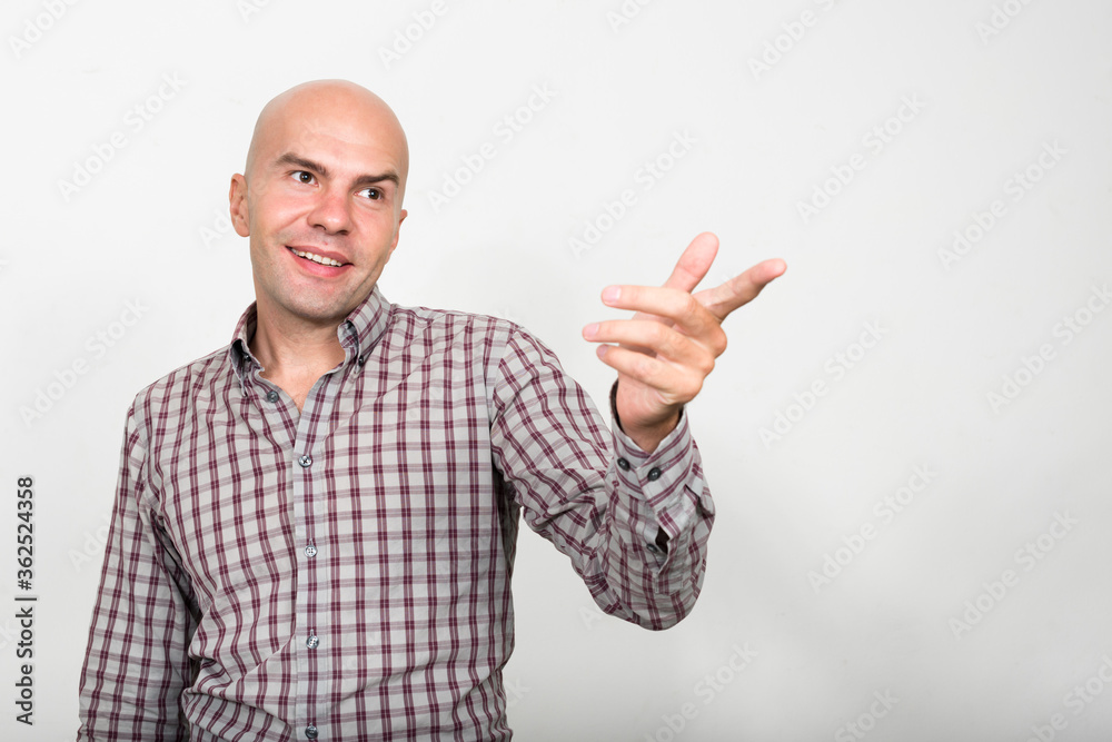 Portrait of happy bald businessman pointing finger Portrait of happy bald businessman pointing finger