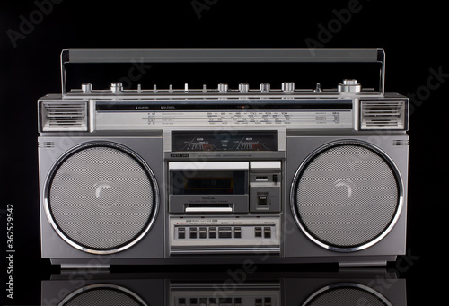 Vintage silver boom box on black background with reflection
