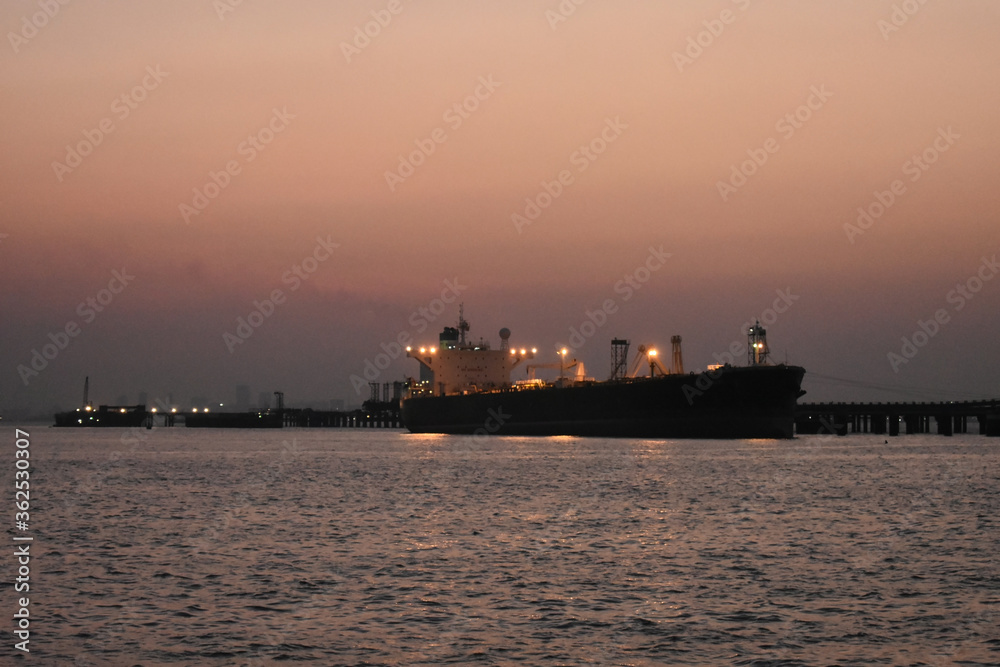 merchant ship standing near mumbai port in evening