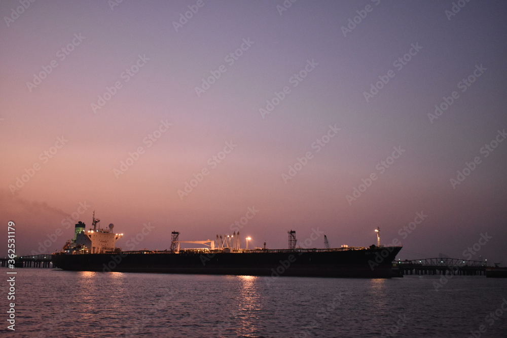 silhouette image of a merchant ship standing in a port
