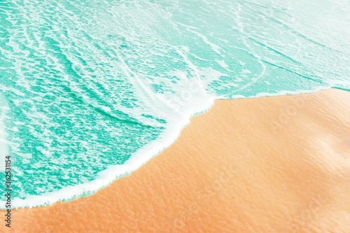 Foto Foamy blue sea wave rolling to sand shore beach
