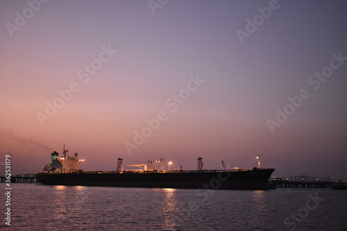silhouette image of a merchant ship standing in a port