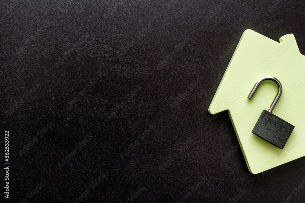Security concept - lock and house figure - on black desk top-down space of text Security concept - lock and house figure - on black desk top-down space of text