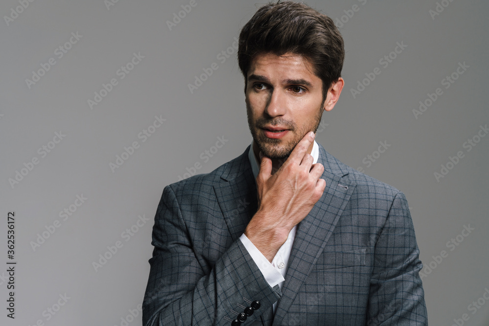 Photo of respectable confident businessman posing and looking aside Photo of respectable confident businessman posing and looking aside