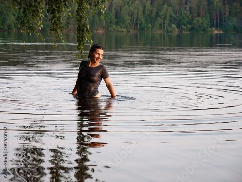Fototapeta Naklejka Na Ścianę i Meble -  beautiful girl bathes in a lake at sunset