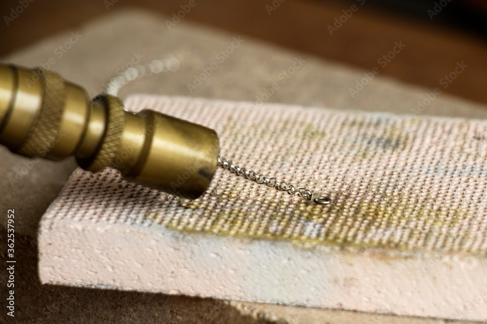 Goldsmiths tools on the jewelry workplace. Tools over rustic wooden background.