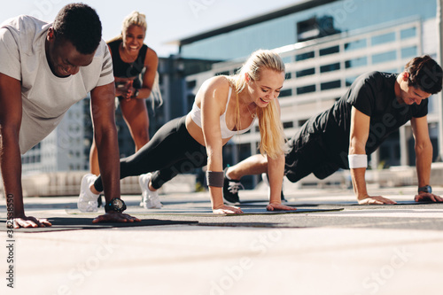 Group of people doing push ups outdoors