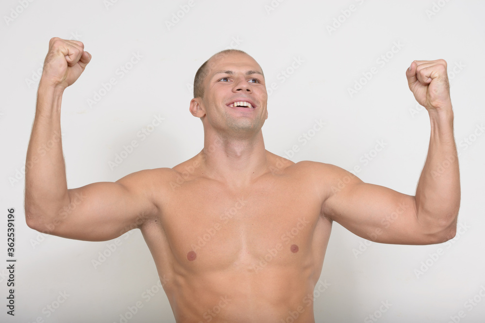Happy young muscular bald man getting good news shirtless Happy young muscular bald man getting good news shirtless