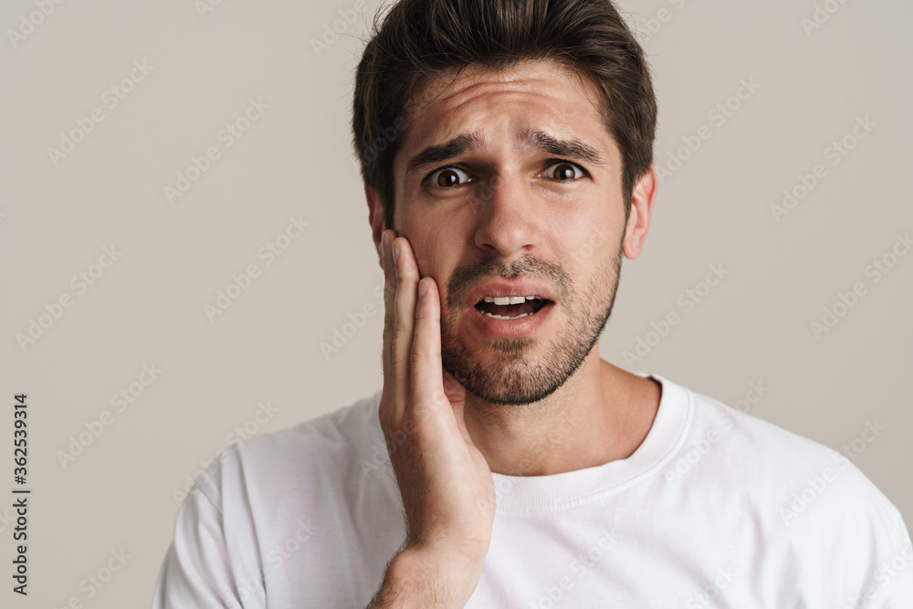 Portrait of displeased young man expressing surprise on camera