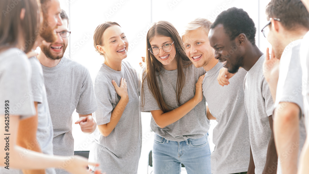 group of happy young people standing in a bright room group of happy young people standing in a bright room