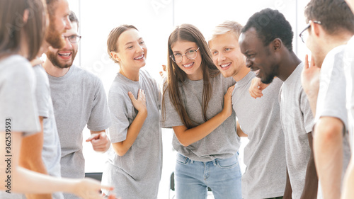 group of happy young people standing in a bright room
