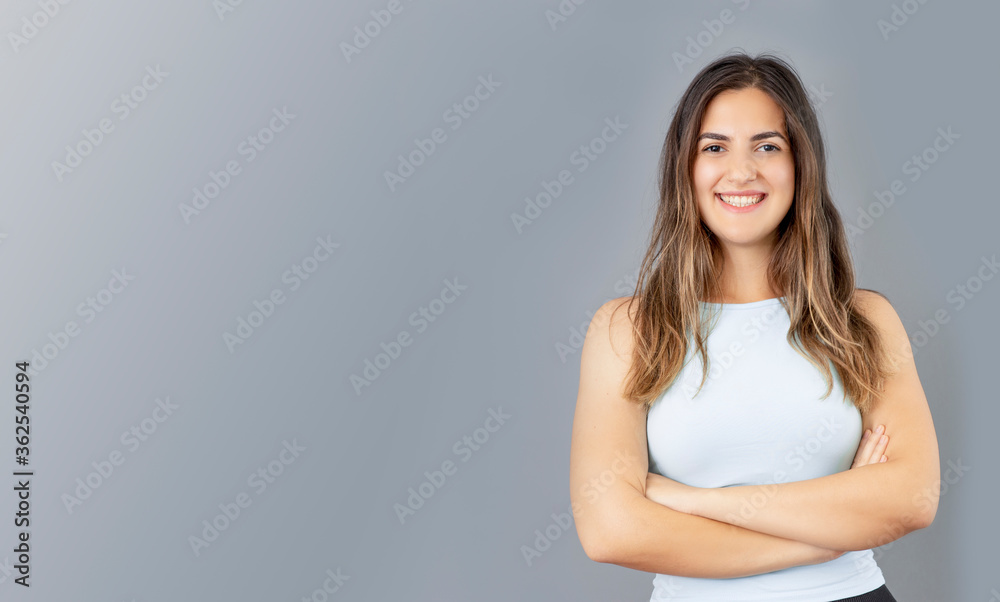 Beutiful Turkish young woman crossed arm posing in confident mood and smiling, grey background studio shot. Beutiful Turkish young woman crossed arm posing in confident mood and smiling, grey background studio shot.
