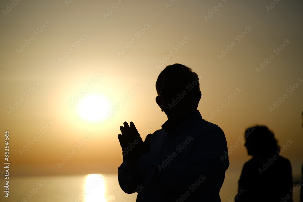 silhouette of a man praying