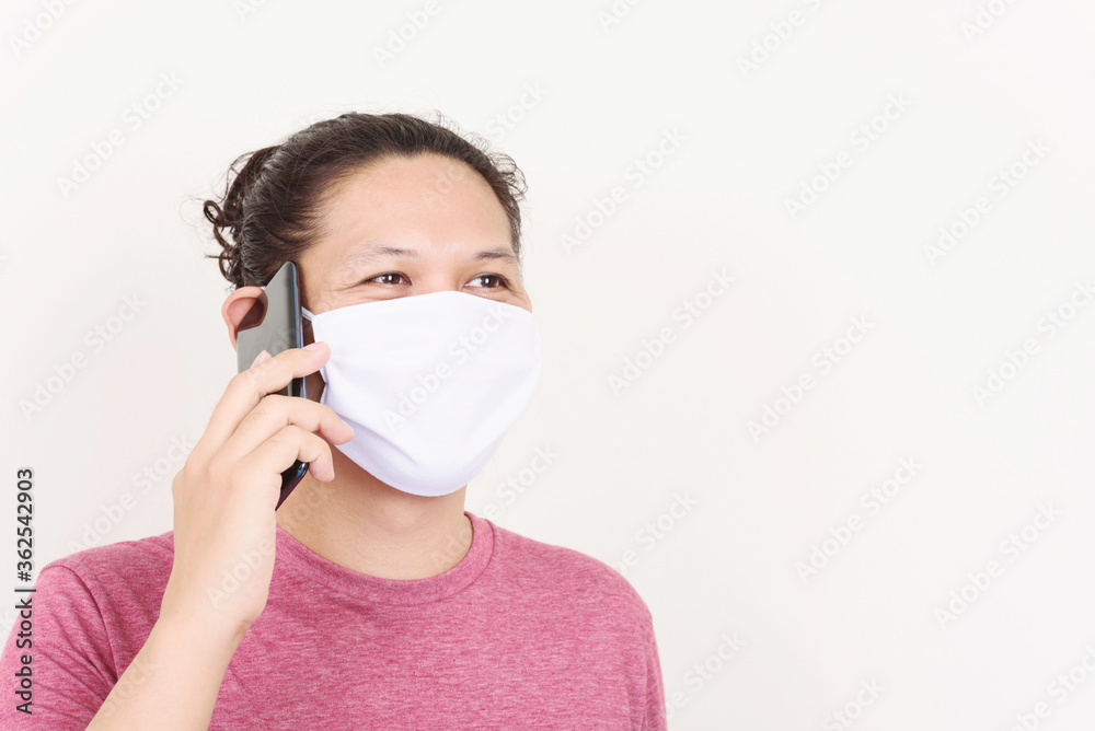 Portrait of Asian man wearing white fabric mask and talking on mobile phone Portrait of Asian man wearing white fabric mask and talking on mobile phone
