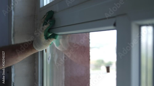 Worker put window sash into new installed frame. Close up of hand