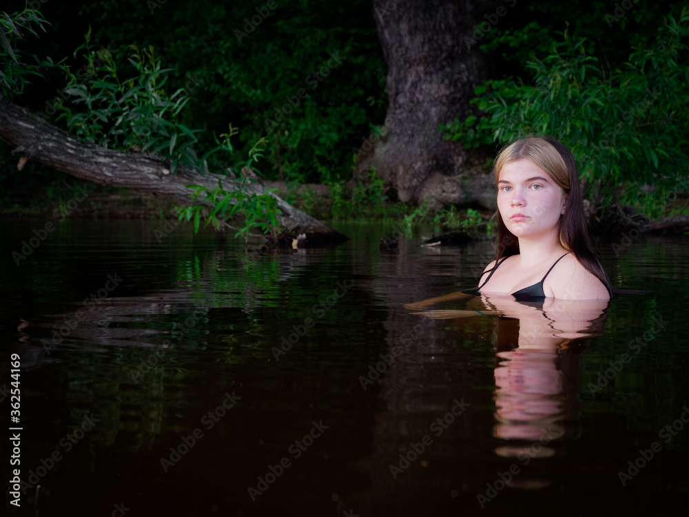 girl is reflected in the dark water at sunset girl is reflected in the dark water at sunset