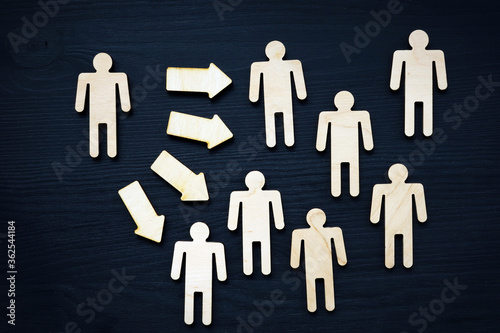 Assertiveness or leadership concept. Small figure, arrow and crowd. photo