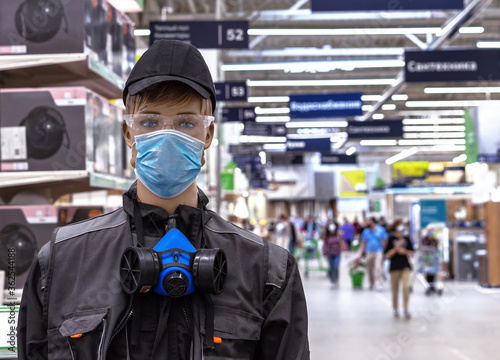 Male mannequin in work clothes with a protective medical mask on his face.