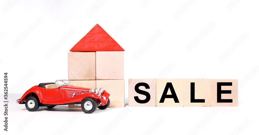 Obraz premium Sale tex on wooden cubes on a white background. near a house with ku cubes and a red car. house for sale on backgrouund