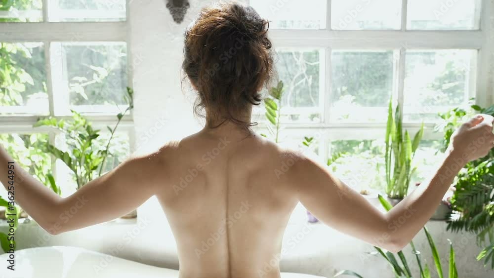 Slim woman undressing white towel near the bathtub and posing. Slowmotion. Slim woman undressing white towel near the bathtub and posing. Slowmotion.