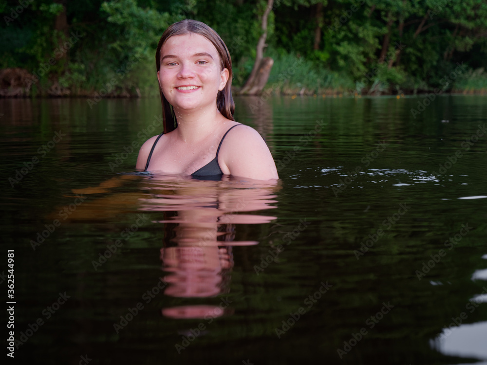 mermaid girl in the water among water lilies at sunset