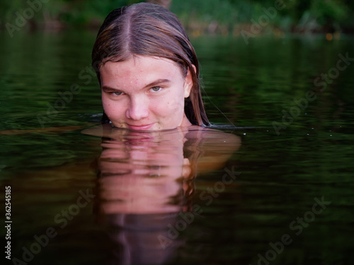 Fototapeta Naklejka Na Ścianę i Meble -  mermaid girl in the water among water lilies at sunset