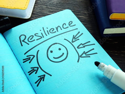 Handwritten word resilience in the blue notebook. photo